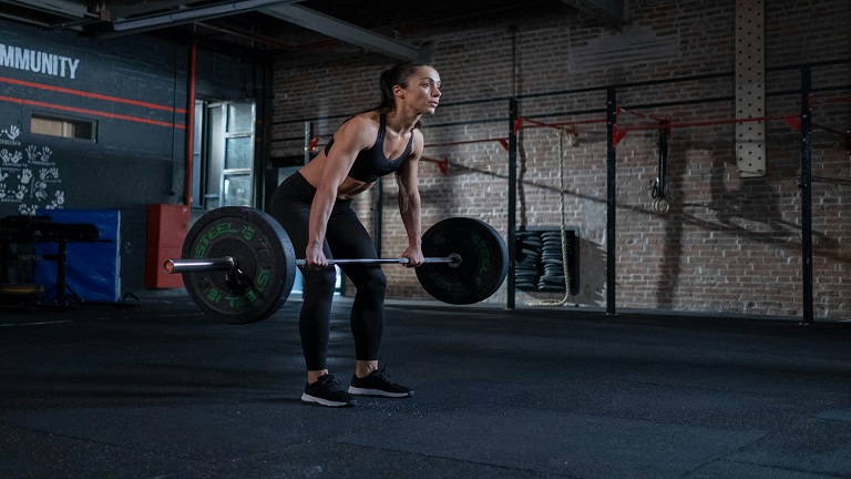 View of lifter performing barbell bent over row in a gym setting
