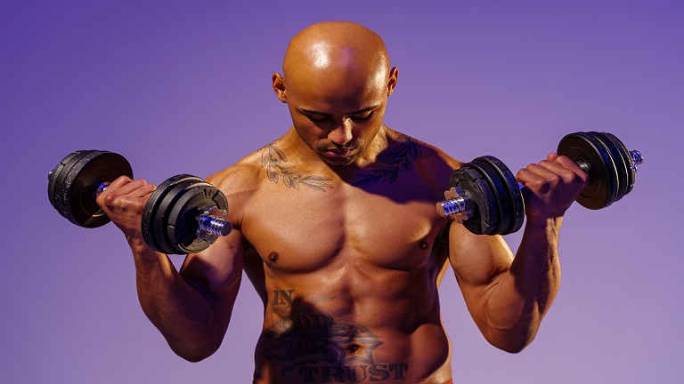 Lifter performing a dumbbell bicep curl with full supination at the top