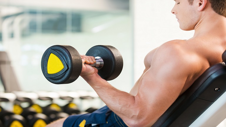 Lifter performing a dumbbell incline curl on a 60 degree incline bench